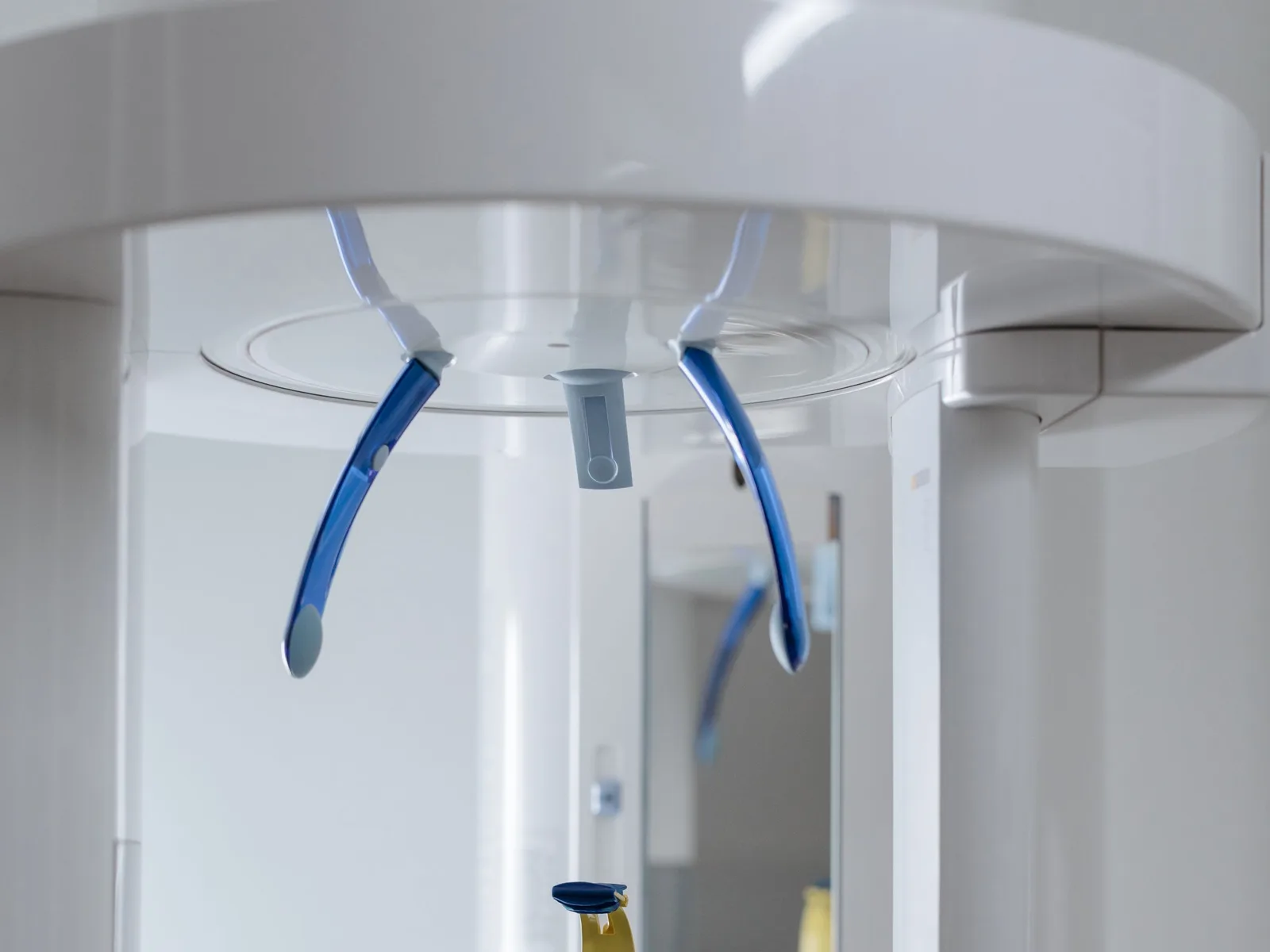 A close detail of modern dental imaging equipment, clean and unoccupied.