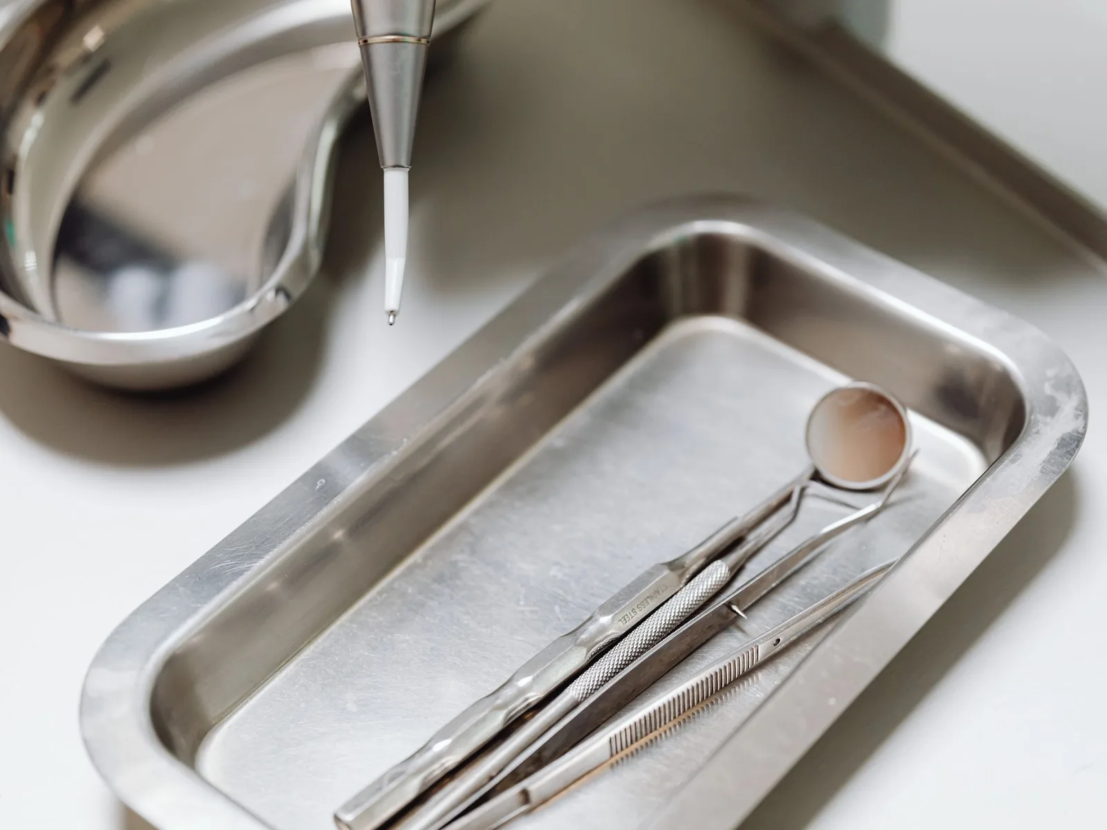 Dental examination instruments laid out on a steel tray, ready for a routine check-up.